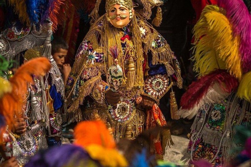 A person in elaborate traditional attire with intricate jewelry and a headdress. 4