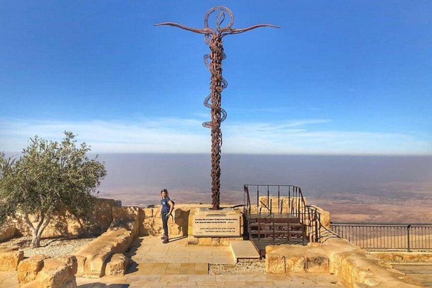 Una escultura de metal con una parte superior circular, una escalera que lleva hasta ella y una vista despejada del horizonte. 2
