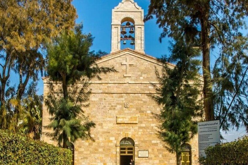 A stone church with a bell tower, surrounded by trees. 4