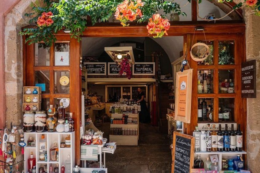 A shop with a wooden facade, glass display cases, and hanging flowers. 2