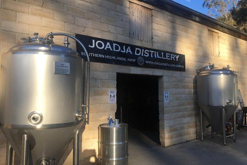 En destilleributik med store ståltanke og et skilt der siger 'JOADJA DISTILLERY SOUTHERN HIGHLANDS NSW'. 4