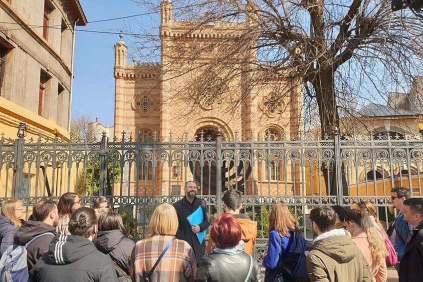 A group of people gathered in front of a historic building with intricate architecture. 3