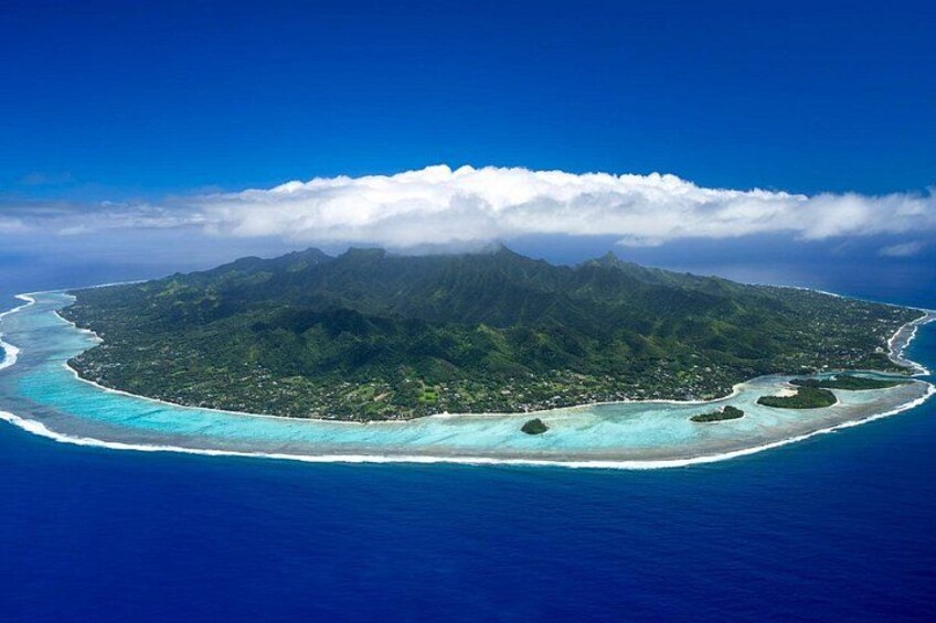 An aerial view of a tropical island with a clear blue ocean, a white sandy beach, and lush green mountains. 3