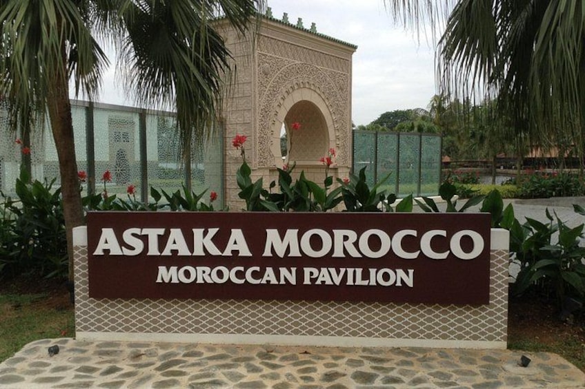 A sign for Astaka Morocco Pavilion with a decorative arch and palm trees. 4