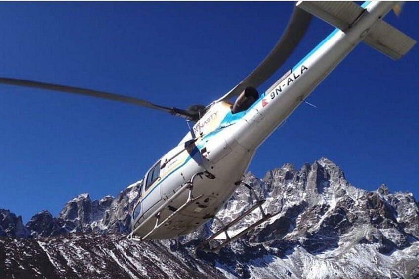Un helicóptero con la matrícula GN-ALA sobrevolando un paisaje montañoso. 1