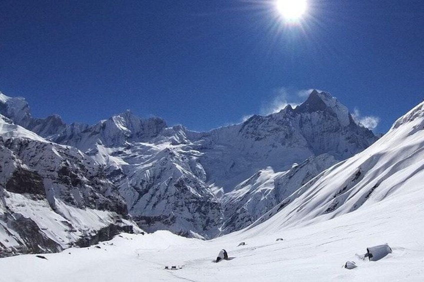 Paisaje montañoso nevado con cielo despejado y sol brillante. 5