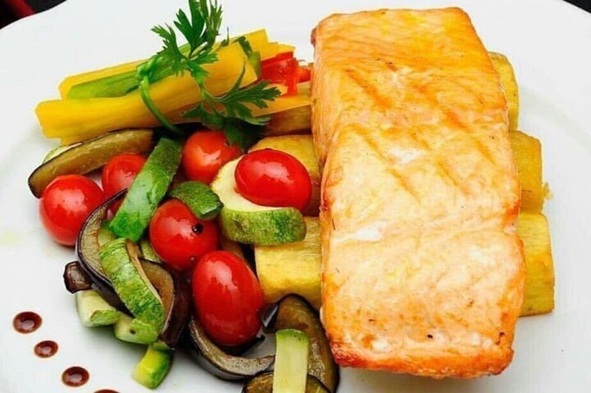 Een bord met gegrilde zalm, kerstomaatjes, courgette en gele paprika. 2