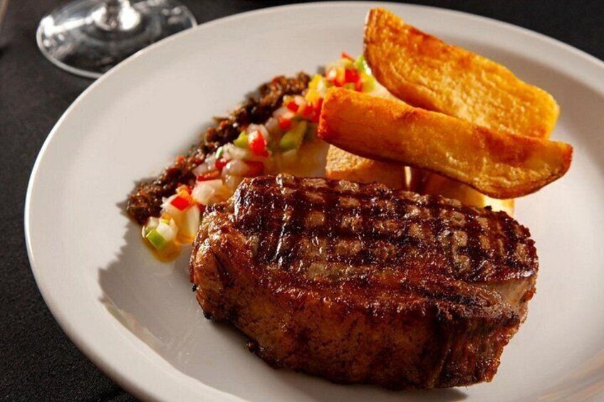 Een gegrild steak met toast en een portie salsa op een bord. 3