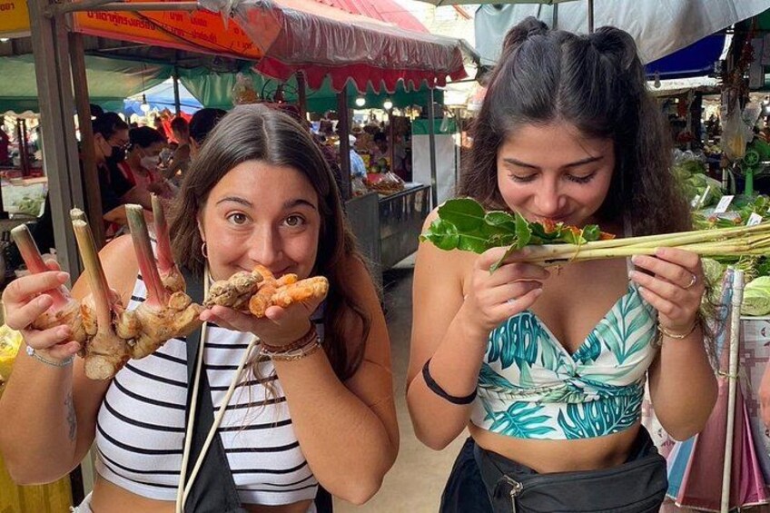 Dos personas sosteniendo alimentos en un mercado. 5