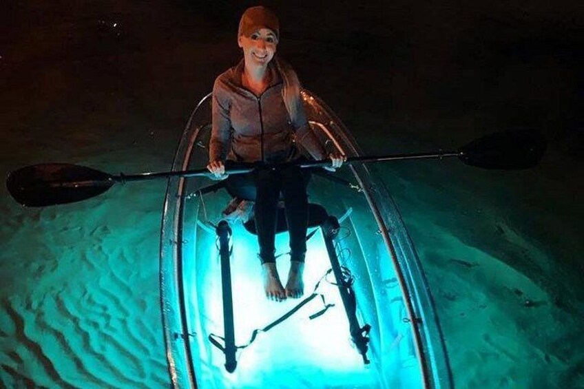 A person in a kayak on a sandy beach at night. 4
