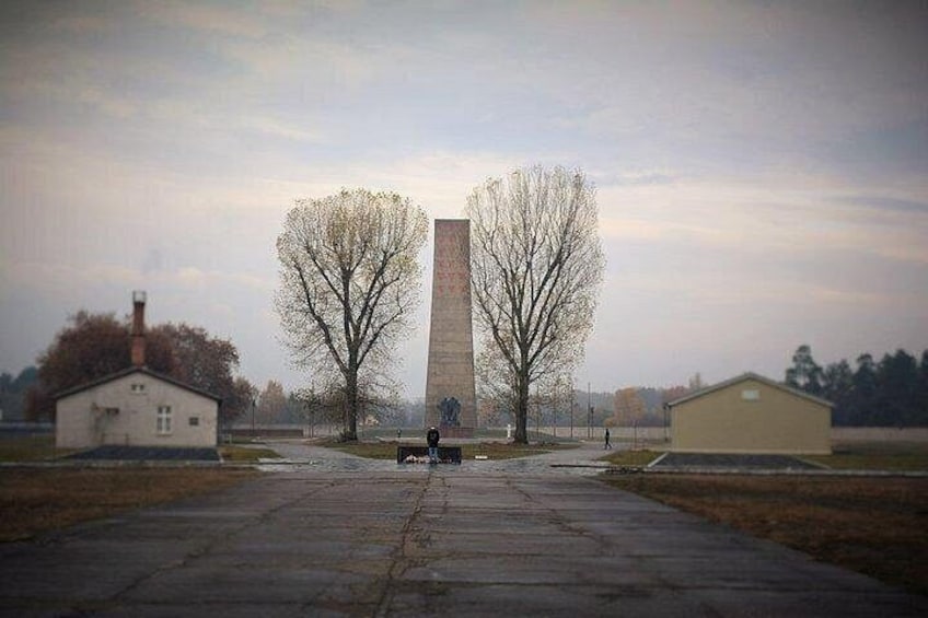 Un grand monument avec un banc devant, entouré d’arbres sans feuilles et sous un ciel dégagé. 2
