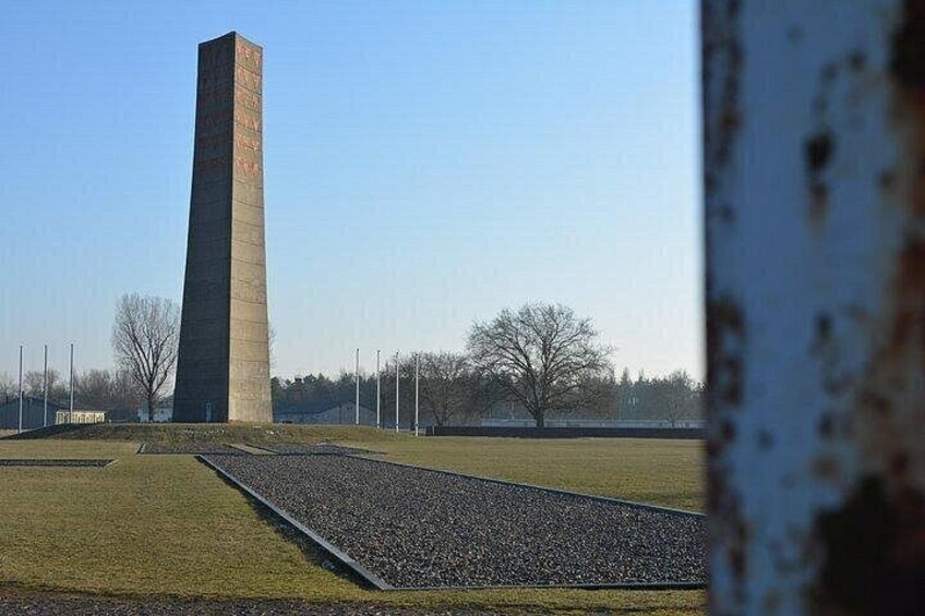 Un monument haut et étroit, situé dans un champ verdoyant, sous un ciel dégagé. 3