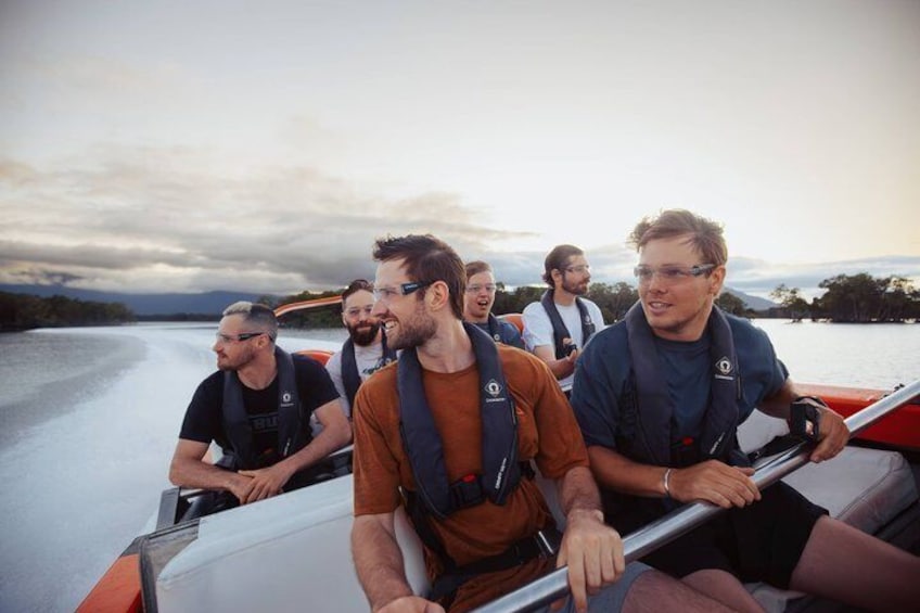 Eine Gruppe von Menschen in Schwimmwesten auf einem Boot auf dem Wasser, bewölkter Himmel. 2