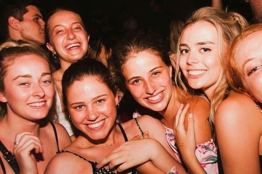 A group of people in close proximity, some with their arms around each other, suggesting a social gathering. 5