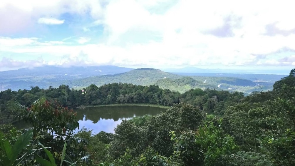 A lake surrounded by dense forest and hills. 5