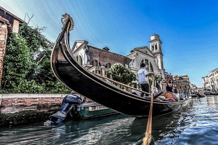 Una góndola en un canal con un edificio histórico al fondo. 5