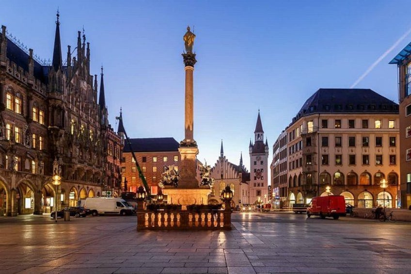 A historic square with a central monument, ornate buildings, and a clear sky. 1
