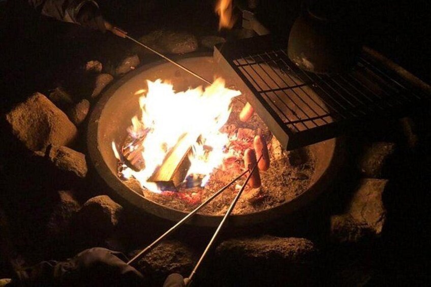 Un fuoco da campo con una griglia, circondato da rocce. 3