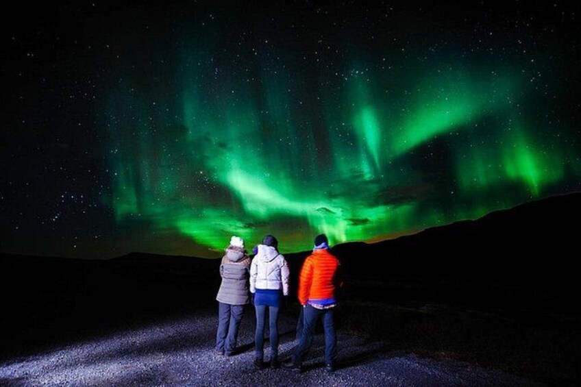 Tre persone che ammirano l'aurora boreale. 5