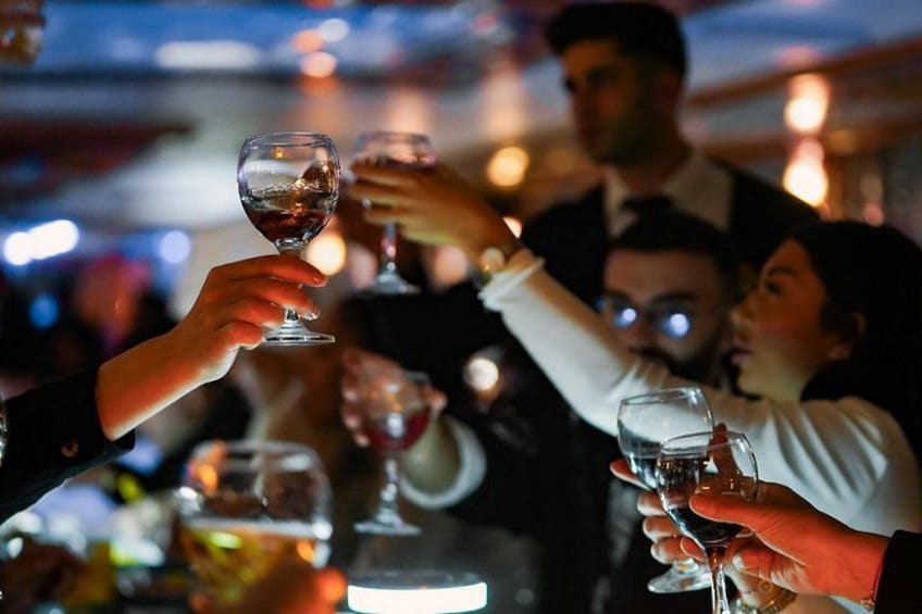 Des personnes trinquent avec des verres de vin dans un endroit à la lumière tamisée. 5