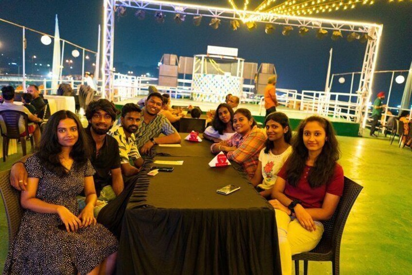 A group of people seated at a table outdoors at night. 4
