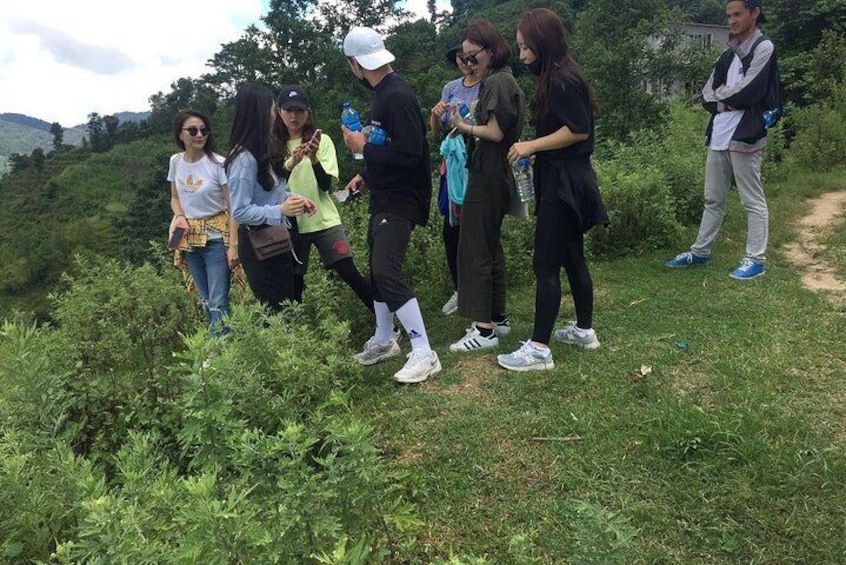 Un groupe de personnes se tient sur un sentier herbeux, dans un cadre naturel. 5
