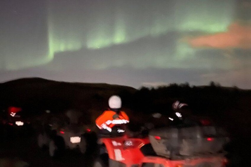 A person on a motorcycle, a vehicle, and a landscape with a greenish sky. 3