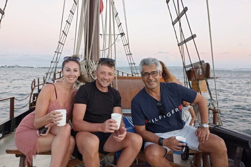 A group of people on a sailing boat with sails and rigging visible. 1