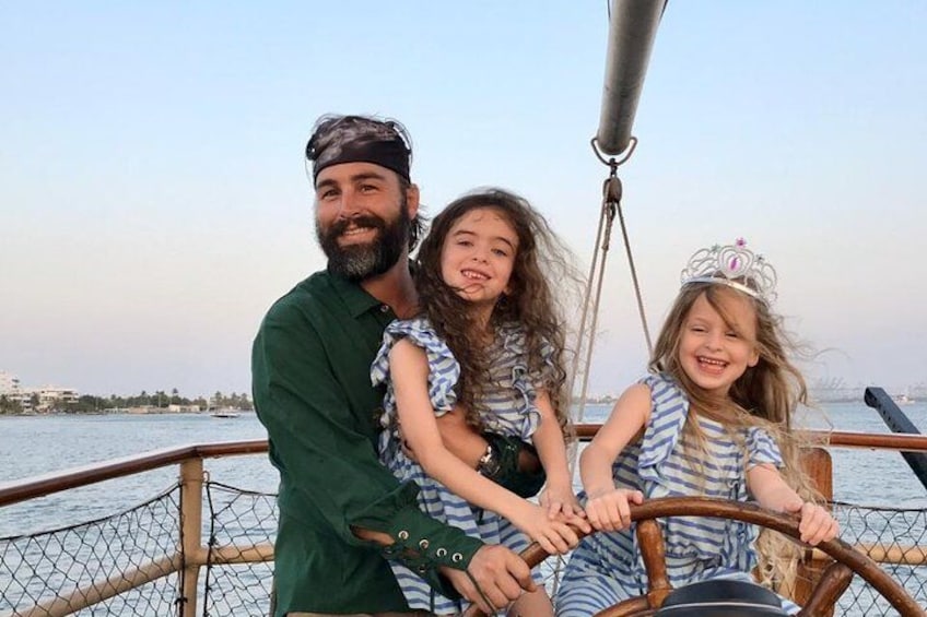 A boat with a person steering and two children sitting in the front. 4