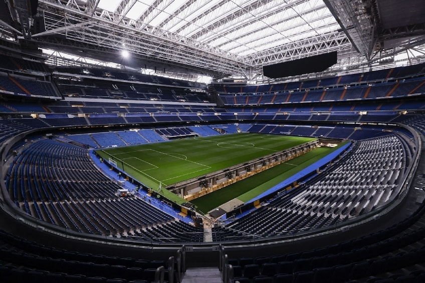 Un estadio grande y vacío con un campo central y asientos en forma de graderío. 1