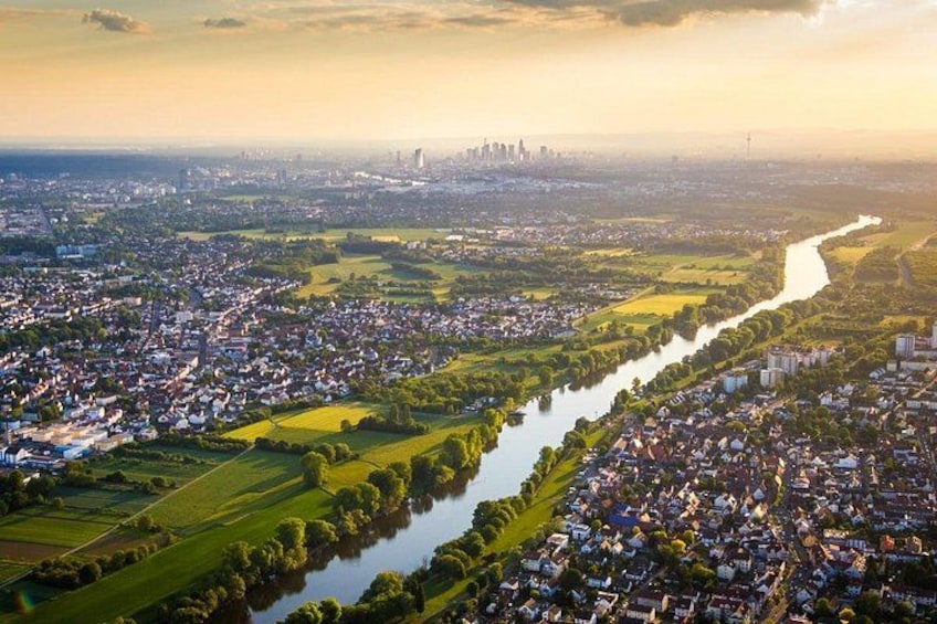 A river winding through a densely populated urban area with a distant city skyline. 2