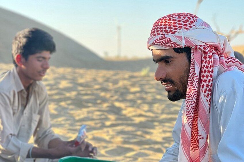 Dos personas en un paisaje desértico, una sosteniendo una botella. 1