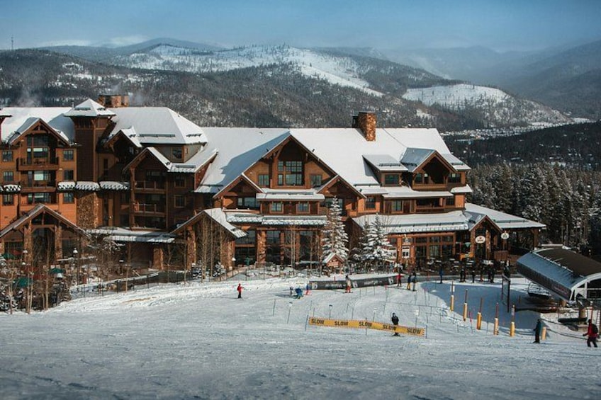 A lodge with a snow-covered roof, surrounded by a snowy landscape and mountains in the background. 4