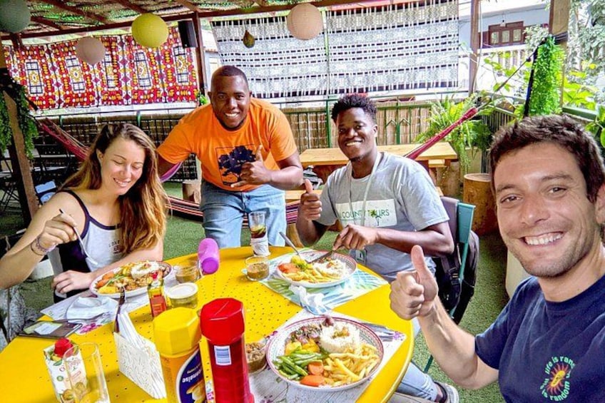 Un grupo de personas cenando al aire libre en una mesa con comida y bebidas. 5