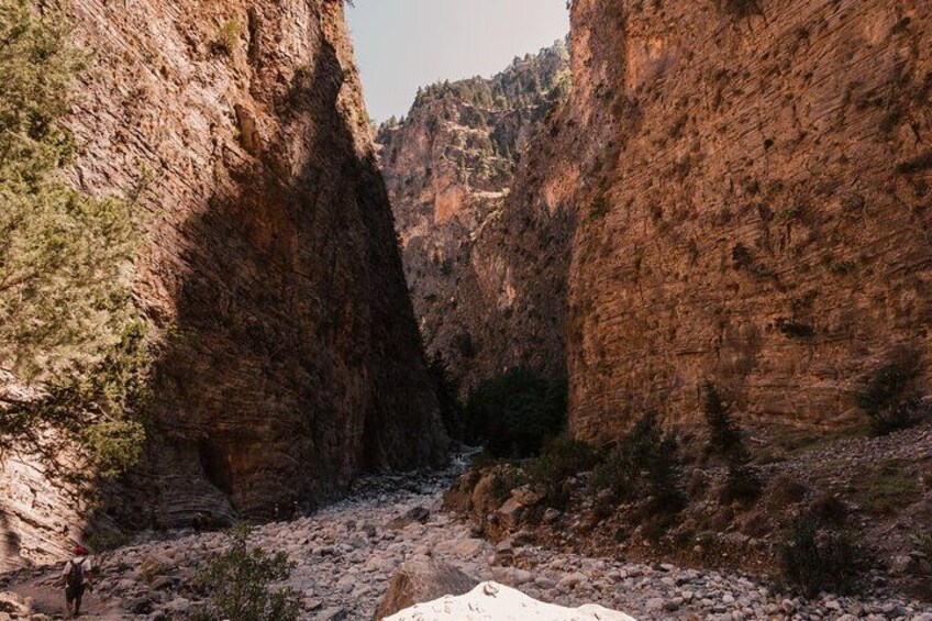 A canyon with steep rock walls and a river flowing through it. 2