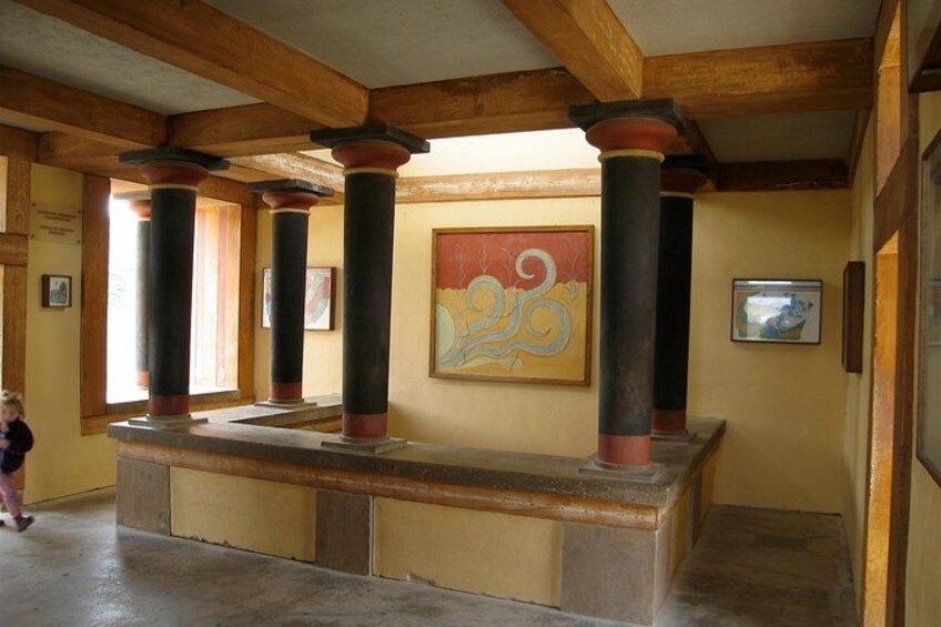 Un hall d’entrée avec des poutres en bois, des colonnes, un banc et une peinture abstraite aux couleurs vives. 3