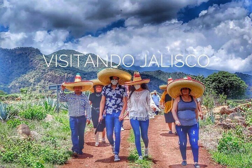 Un grupo de personas caminando por un sendero, con un paisaje montañoso al fondo. 1
