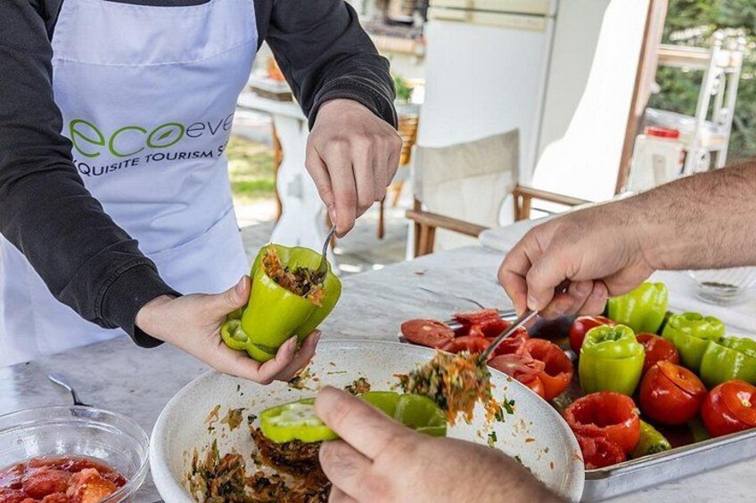 Eine Person bereitet Essen zu, insbesondere füllt sie einen Paprika mit einer Füllung. 2