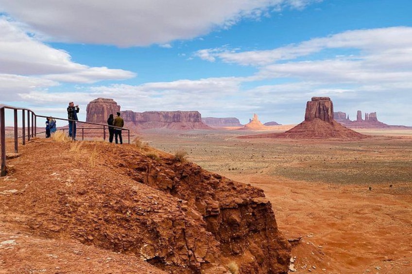 A desert landscape with a prominent rock formation and a fence. 4