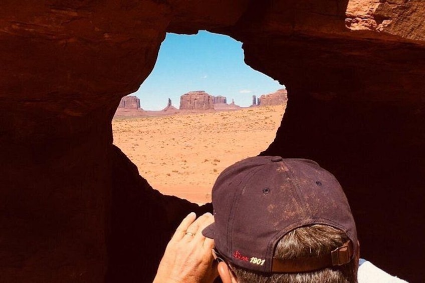 Une personne se trouve à l’intérieur d’une grotte, d’où l’on peut admirer un paysage désertique. 5