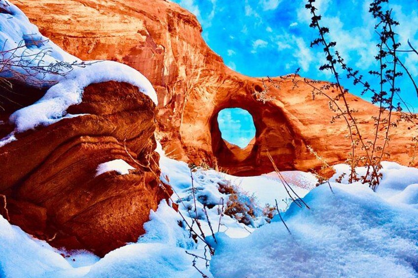 Une formation rocheuse recouverte de neige, surmontée d’une arche naturelle. 2