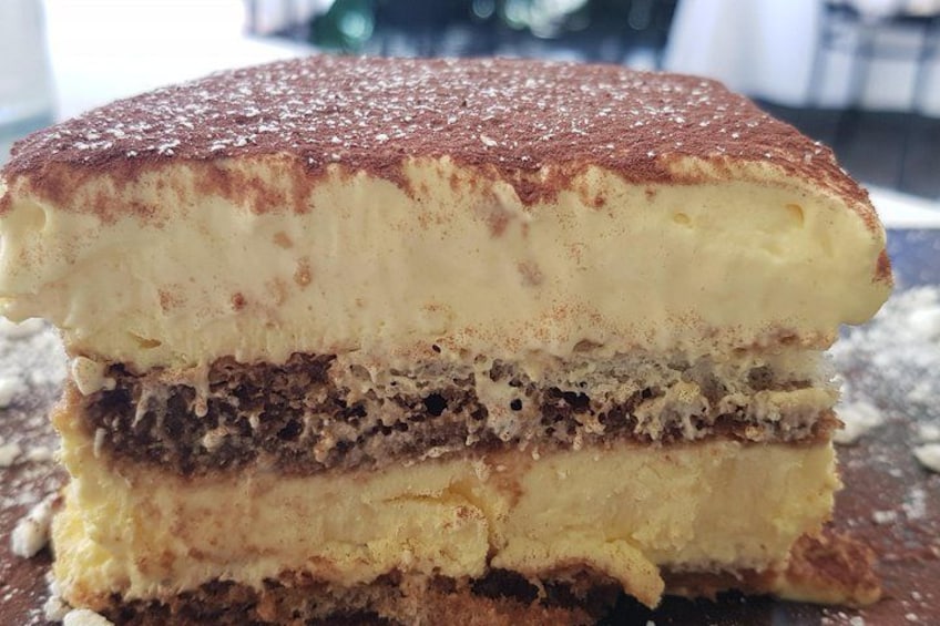 A layered dessert with a dusting of cocoa powder on top. 1