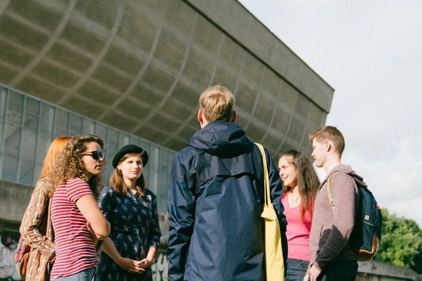 Un grupo de personas de pie al aire libre cerca de un edificio moderno con fachada de vidrio. 5