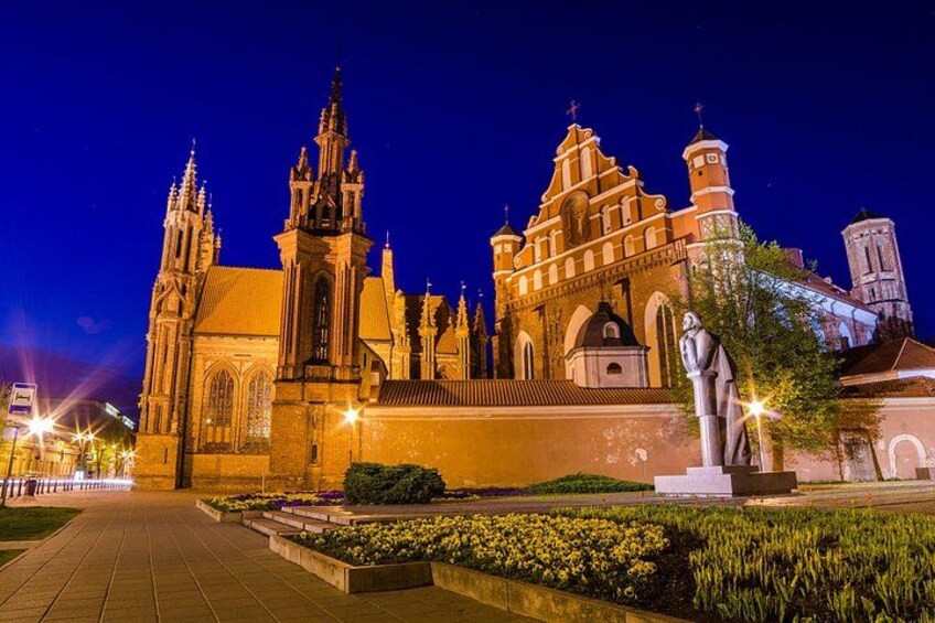 A cathedral with multiple spires, a statue, and a well-maintained garden. 3