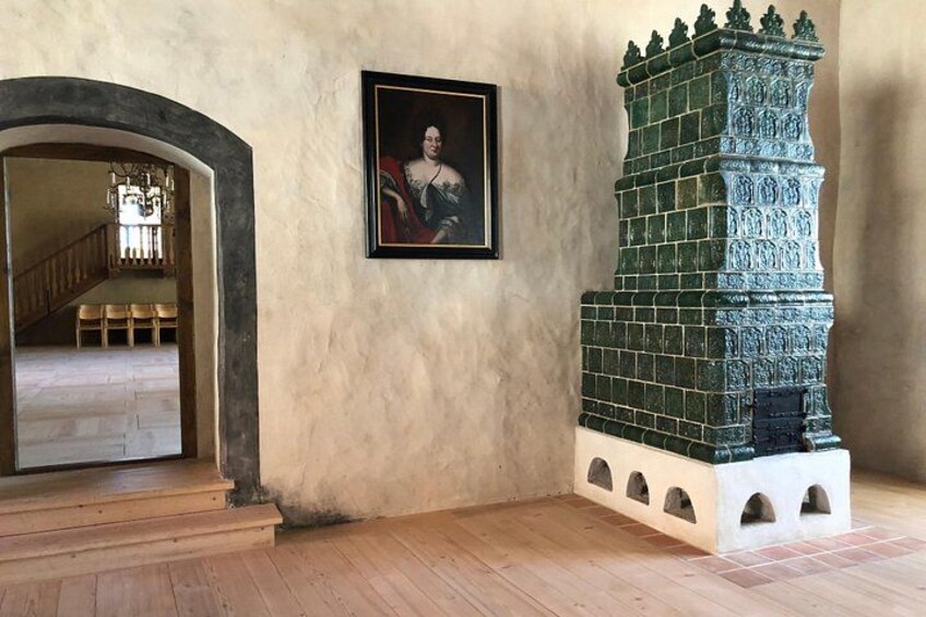 Una stanza con una scala, un ritratto incorniciato e una torre decorativa. 4