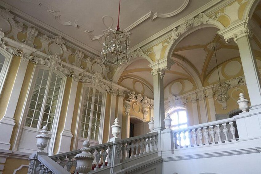 Un interno decorato con una scalinata monumentale, modanature elaborate e un lampadario. 5