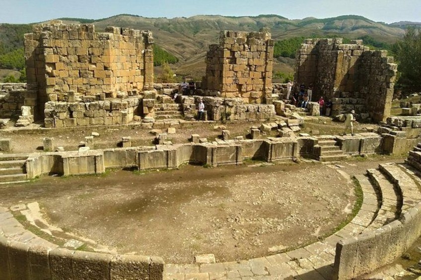 Ancient ruins with stone structures and a circular amphitheater. 2