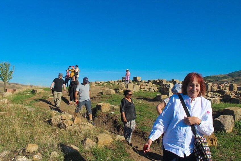 A group of people hiking on a rocky terrain with a clear blue sky. 5