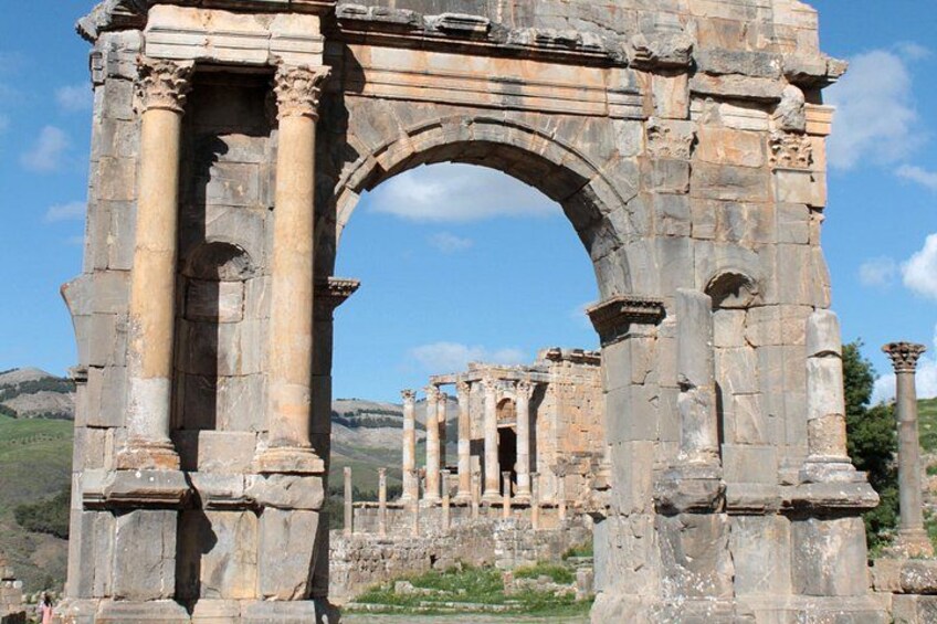 Ancient stone ruins with columns and an archway. 2