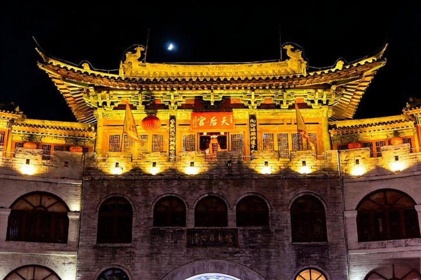 Ein traditionelles chinesisches Gebäude mit aufwendiger Architektur, beleuchtet durch künstliches Licht. 4